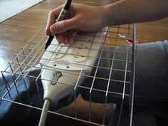 a person sitting on the floor with a remote control in front of them and holding a pen