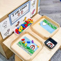 two wooden trays filled with colorful candy and gummy bears on top of a table