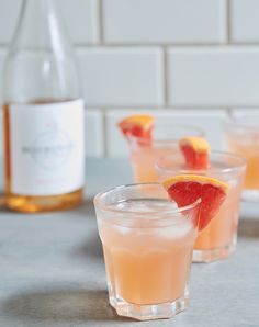 three glasses filled with grapefruit and orange juice