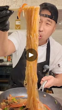 a man is making noodles in a wok