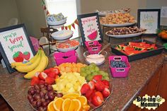 a table filled with lots of fruit and desserts on top of it's counter