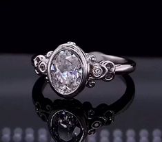 an oval shaped diamond ring with filigree accents