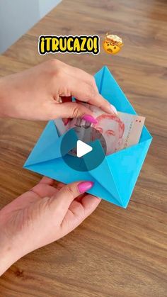 someone is opening an origami envelope on a table with the words truccazo written above it