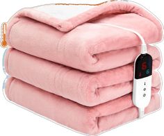 three pink blankets stacked on top of each other with an alarm clock in the middle