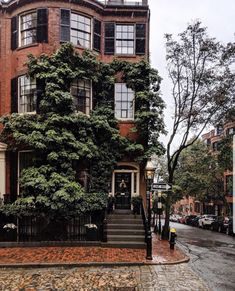 an old brick building with ivy growing on it's side and stairs leading up to the door