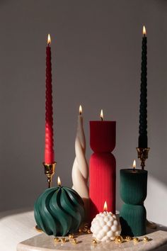 three candles are sitting on a table with other decorative objects around them, including one candle