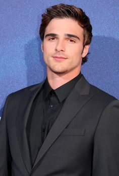 a young man in a suit and tie posing for the camera at an awards event