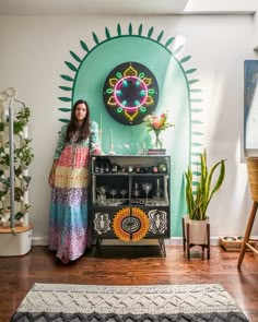 a woman standing in front of a colorful wall with an art work on the wall