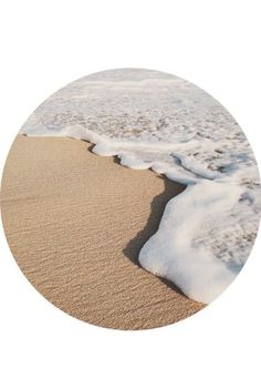 the sand and water are covered in white foamy snow, as well as small waves