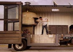 a man standing on the back of a truck