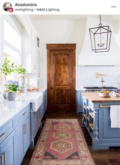 a kitchen with blue cabinets and an area rug