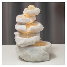 a white stone fountain with yellow lights on it