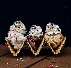 three ice cream cones with sprinkles and chocolate