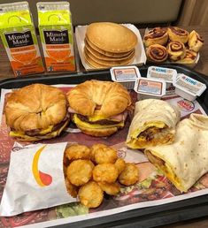 a tray filled with sandwiches and tater tots next to some other food items