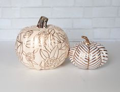 two decorative pumpkins sitting next to each other