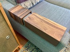 two pieces of wood sitting on top of a blue couch next to a wooden table