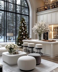 a living room filled with white furniture and a christmas tree in the window sill