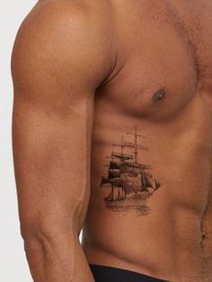 a man's chest with an old ship tattoo on the left side of his stomach