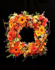 an orange and yellow floral wreath on a black background