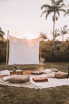 an outdoor movie set up with pillows and blankets