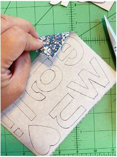 someone is cutting out the letters on a piece of fabric to make a name pillow