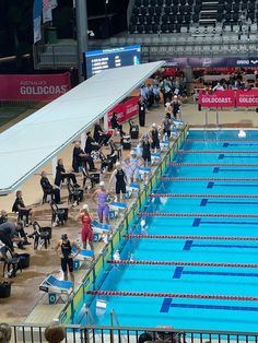 an olympic swimming pool filled with people standing around