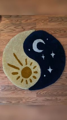 a rug with the sun and moon on it sitting on a wooden floor in front of a door