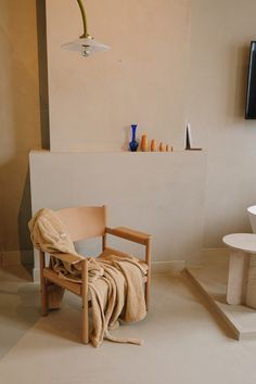 a chair with a towel draped over it in front of a television set and vases