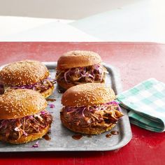 four pulled pork sandwiches on a tray