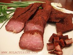 sliced meat on a white plate with green onions