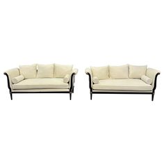 a pair of sofas sitting next to each other on top of a white floor