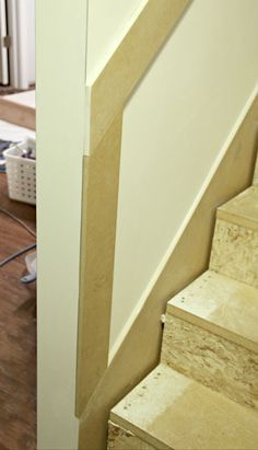 a cat is sitting on the stairs next to a radiator and heater