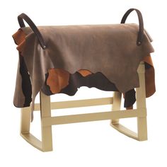 a brown and black blanket sitting on top of a wooden rocking chair with leather straps