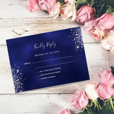 a blue wedding rsp card with white glitter on it and pink roses in the background