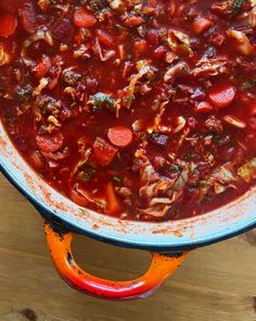 a large pot filled with soup on top of a wooden table