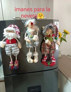 three stuffed animals on display in front of a refrigerator