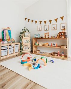 a child's playroom with toys on the floor and shelves in the background