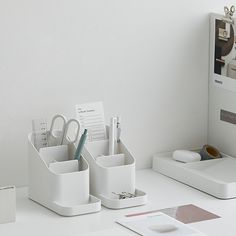 the desk is organized with pens, pencils and other office supplies in white containers