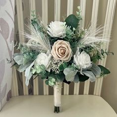 a bridal bouquet sitting on top of a white chair