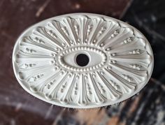 a close up of a white object on a marble surface with an eye in the center