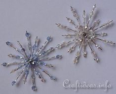 two crystal snowflakes on a white surface