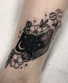 a book and flowers tattoo on the leg with stars, moon and planets in the background