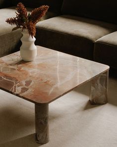 a marble coffee table with a vase on top