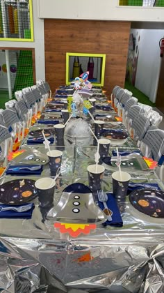 a long table set up with plates and silverware for an event or party,