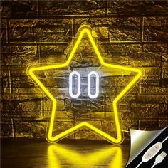 a yellow star shaped neon sign sitting on top of a wooden table next to a brick wall