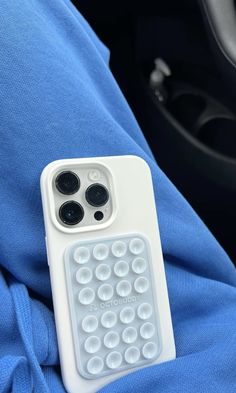 a cell phone case sitting on top of a blue cloth in a car seat next to a steering wheel