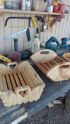 several wooden trays sitting on top of a table next to tools and other items