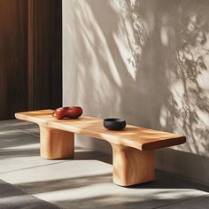 a wooden bench sitting next to a wall with a bowl on it's side