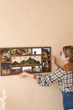 a woman placing pictures on the wall with her hands and pointing at them in order to see if they are missing