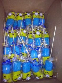 a box filled with blue and yellow cupcakes covered in plastic wrappers next to toothbrushes